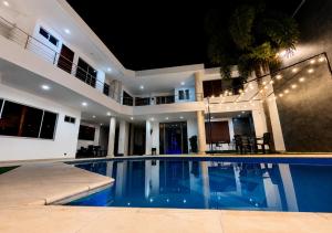 a swimming pool in front of a house at night at Espectacular, Casa Vacacional Jpol in Cali