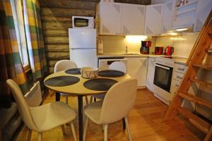 a kitchen with a table and chairs and a refrigerator at Holidayhome Sompio in Luosto
