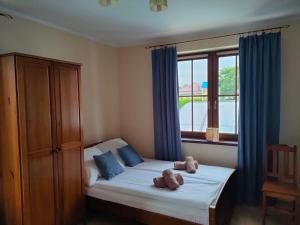 a bedroom with a bed with two teddy bears on it at Apartamenty przy basenie blisko morza Brown in Puck +93 photos
