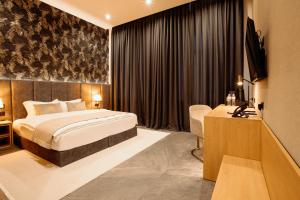 a hotel room with a bed and a television at Diplomatico Hotel in Odesa +28 photos