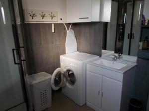 a small bathroom with a washing machine and a sink at studio in Saint-André-de-Sangonis