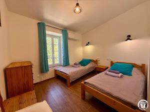 a bedroom with two beds and a window at Château de Prax Viel - piscine et mini ferme, climatisé in Lagrasse +58 photos