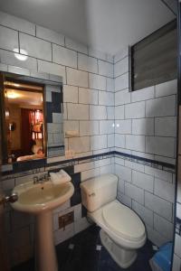 a bathroom with a toilet and a sink and a mirror at Fuente de Agua in Cusco +16 photos