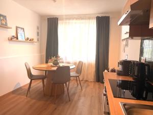 a kitchen with a table and chairs in a room at Apartments Chloe - Top 1 in Hollabrunn