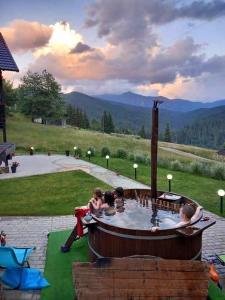 a group of people sitting in a hot tub at Domeniul Barabuc Colibita in Colibiţa