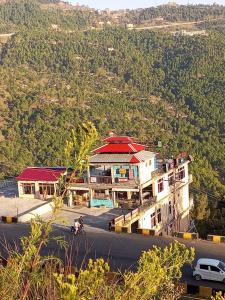 a building on the side of a road with a car at Asghar Ali Resort in Lower Topa