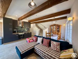 a living room with a blue couch and a kitchen at Château de Prax Viel - piscine et mini ferme, climatisé in Lagrasse