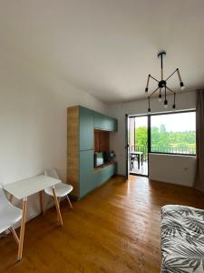 a living room with a table and a dining room at Bazaleti Lake Family Apartment in Chanadirtkari
