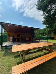 a picnic table in the grass with a building in the background at Bazaleti Lake Family Apartment in Chanadirtkari