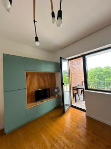 an empty living room with a television and a sliding glass door at Bazaleti Lake Family Apartment in Chanadirtkari