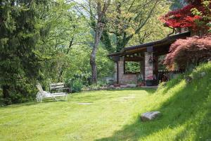 a bench sitting in the grass next to a house at Agriturismo BioBiò in Vobarno