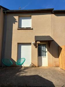 two green chairs sitting in front of a building at maison bozouls in Bozouls +3 photos