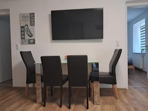 a dining room table with black chairs and a flat screen tv at Self Check-in Apartment DLT - Free Parking in Sankt Marein im Mürztal