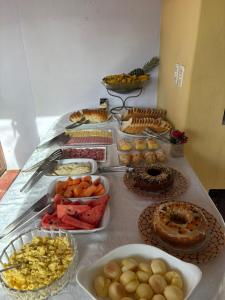 a table topped with lots of different types of food at Pousada Aguas do Mampituba in Torres