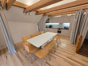 a kitchen and dining room with a white table and chairs at Wellness apartmán Habánská in Pouzdřany +9 photos