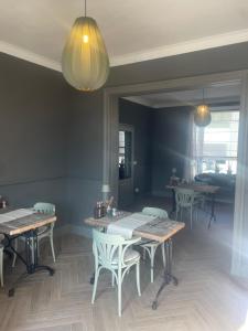 a dining room with wooden tables and white chairs at B&B Tierlantijn in Hamont +51 photos