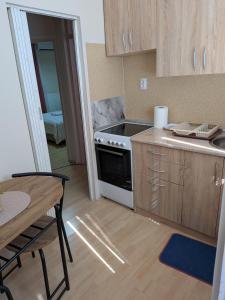 a kitchen with a stove and a table with a tableablish at Apartman Jabuka in Paraćin +5 photos