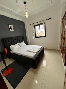 a bedroom with a bed and a window at Western Suites in Douala