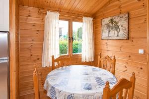 a dining room with a table and a window at Cabaña Las Cebras de Cabárceno in Penagos +9 photos