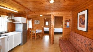 a kitchen and dining room in a log cabin at Cabaña Las Cebras de Cabárceno in Penagos