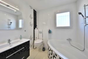 a bathroom with a tub and a toilet and a sink at Villa Fontenailles in Mâcon +25 photos