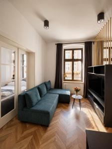 a living room with a blue couch and a television at CanvasHome Apartamenty Aparthotel 250m od Rynku in Katowice