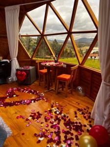 a room with a table and a bunch of flowers on the floor at GLAMCAPTOUR in Guatavita