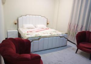 a small bedroom with a bed and two chairs at Asghar Ali Resort in Lower Topa