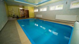 a large swimming pool with blue water in a room at Chata Motocentrum in Snina +45 photos
