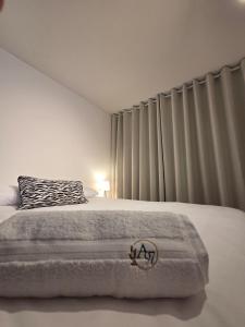 a white bedroom with a bed with a pillow and curtains at Andes 97 Guest House in Bogotá +13 photos