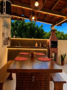 a wooden table with red flowers on a patio at Recanto da Caatinga in Piranhas