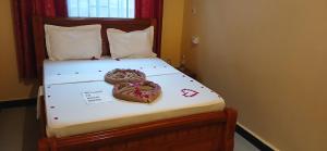 two donuts sitting on top of a bed at Matui House in Kinyasini
