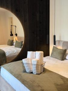 a bedroom with two beds and a basket of towels at Akacia Chalet in Moieciu de Jos