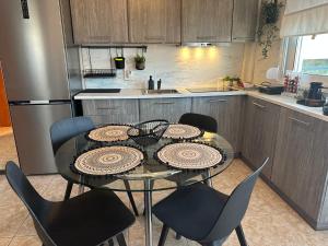 a kitchen with a table and chairs in a kitchen at Sun Sight - Deluxe Meridian Vista Suites in Pefkochori