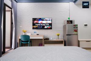 a room with a bed and a tv on a wall at JOY APARTMENT TAY HO in Hanoi