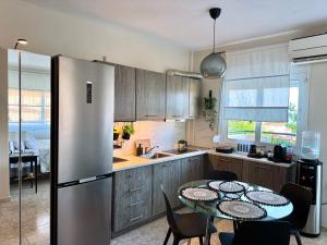 a kitchen with a table and a refrigerator at Sun Sight - Deluxe Meridian Vista Suites in Pefkochori