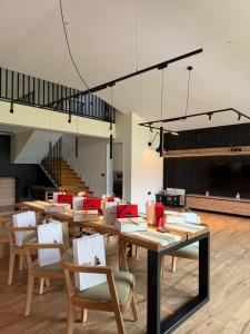 a dining room with tables and chairs and a staircase at Akacia Chalet in Moieciu de Jos