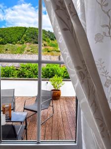 a balcony with a table and chairs and a window at Galerie Riesling in Trittenheim