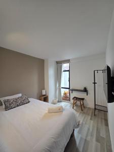 a bedroom with a large white bed and a window at Andes 97 Guest House in Bogotá
