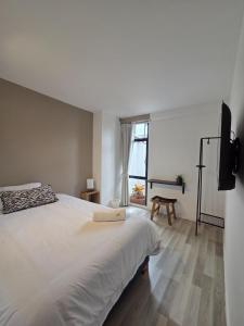 a bedroom with a large white bed and a window at Andes 97 Guest House in Bogotá