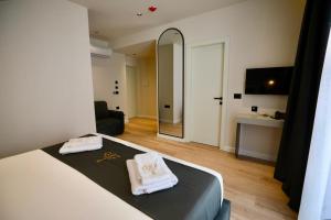 a bedroom with a bed and a mirror in a room at Zeo Hotel Saranda in Sarandë