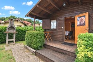 a small wooden cabin with a porch and a table at Cabaña Los Leones de Cabárceno in Penagos +4 photos