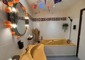 a bathroom with a tub and a sink at Ciné Lodge Lourdes in Lourdes