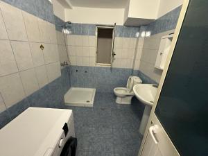 a blue and white bathroom with a toilet and sink at Bledis Apartments in Lushnjë