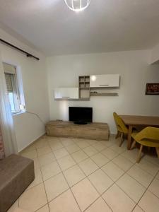 a living room with a tv and a table at Bledis Apartments in Lushnjë