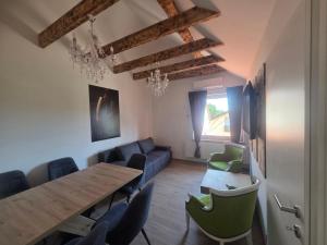 a living room with a wooden table and chairs at Apartmaji Picasso Design in Veržej