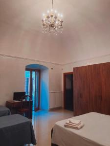 a room with two beds and a chandelier at B&B Rosy in Corato