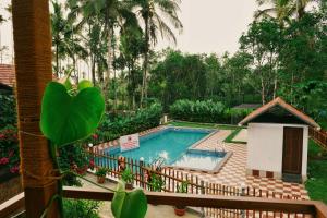 a swimming pool in a garden with a fence at MT'S Villas in Batheri