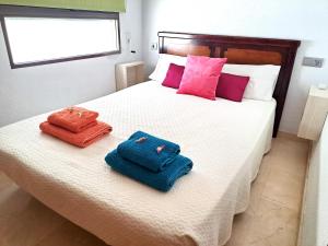 two towels sitting on a bed in a bedroom at Central & Spacious Miraflores Alicante - High Rated in Alicante