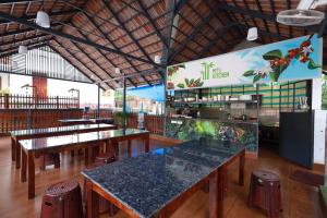 a restaurant with tables and chairs and a menu at MT'S Villas in Batheri